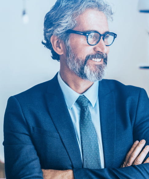 Man in suit smiling with arms folded